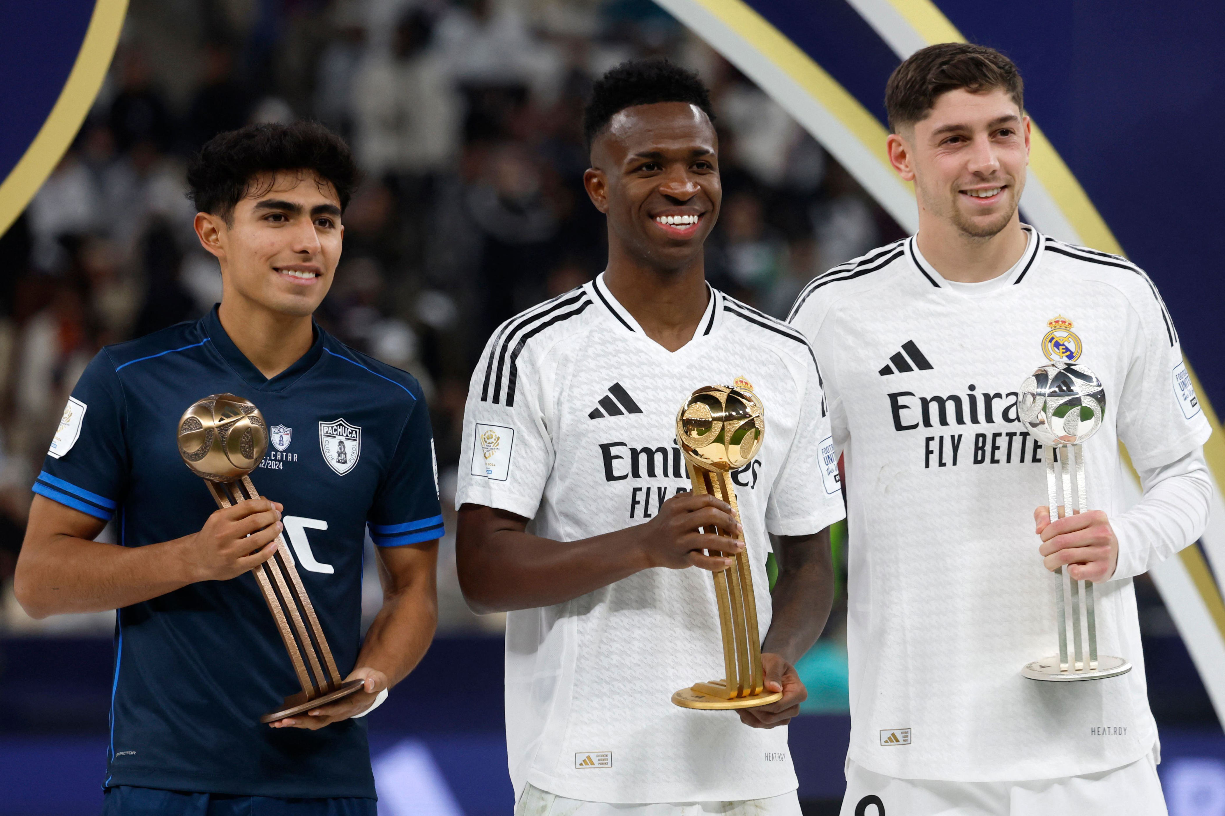 Real Madrid's Brazilian forward #7 Vinicius Junior (C), Uruguayan midfielder #8 Federico Valverde (R), and Pachuca's Mexican midfielder #28 Elias Montiel (L) pose with their gold, silver, and bronze trophies during the podium ceremony after the 2024 FIFA Intercontinental Cup final football match between Spain's Real Madrid and Mexico's Pachuca at the Lusail Stadium in Doha on December 18, 2024. (Photo by KARIM JAAFAR / AFP)