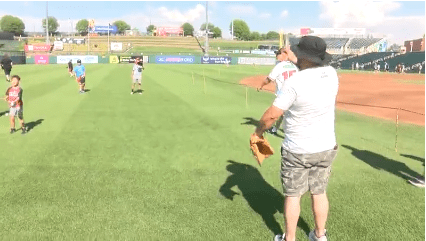Fathers and their kids play catch on Isotopes field
