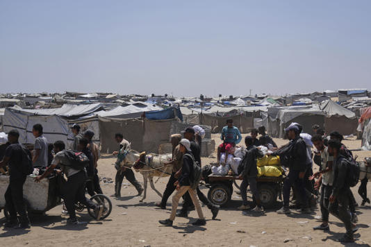 Palestinians carry bags containing food and humanitarian aid packages delivered by the Gaza Humanitarian Foundation, a US-backed organisation, in Rafah, southern Gaza Strip (AP)