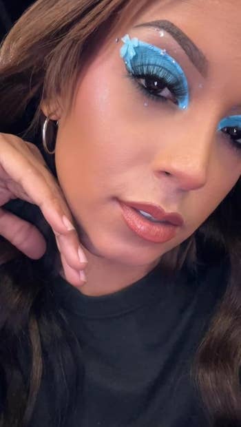 Person with blue eye makeup and butterfly detail