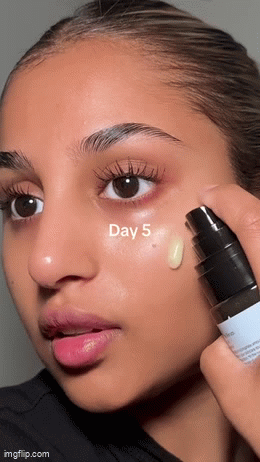 Close-up of a person applying skincare product labeled