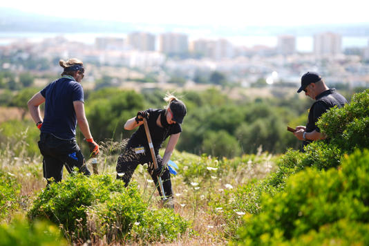 Searchers on Thursday using hand tools (James Manning/PA Wire)