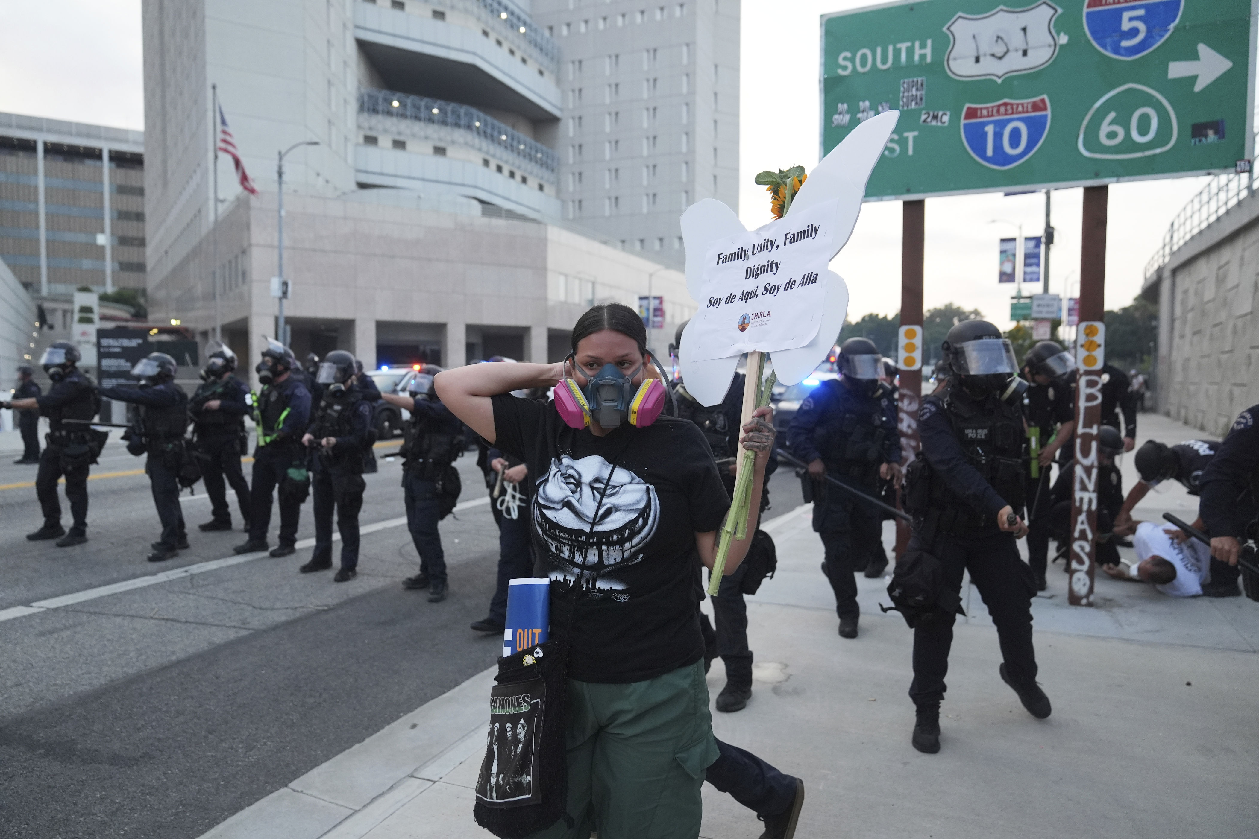 A protester stands in front of Los Angeles Police Department officers attempting to disperse a protest after federal immigration authorities conducted an operation.