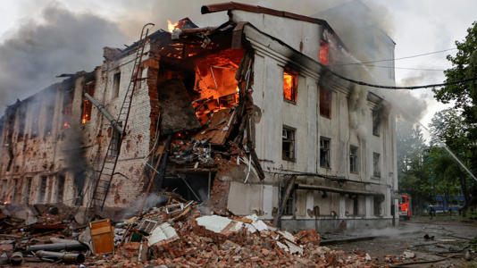 Firefighters work at the site of a building hit by a Russian drone strike in Kharkiv. Pic: Reuters