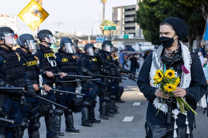 Manifestante olha para policiais durante protesto em Los Angeles, Califórnia Foto: Ringo Chiu/AFP