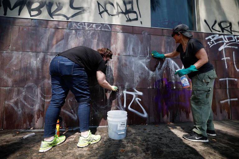 Social activists and artists take graffiti off from the Japanese American National Museum, after days of protests against federal immigration sweeps and the deployment of the California National Guard and U.S. Marines, in Little Tokyo, Los Angeles, California, U.S., June 10, 2025.  REUTERS/Mike Blake