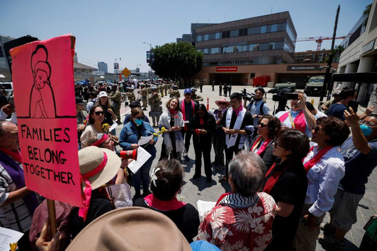 A religious group gathers to sing as  of the California National Guard stand guard outside the Edward R. Roybal Federal building, after days of protests against federal immigration sweeps and the deployment of the California National Guard and U.S. Marines, in downtown Los Angeles, California, U.S., June 10, 2025.  REUTERS/Mike Blake