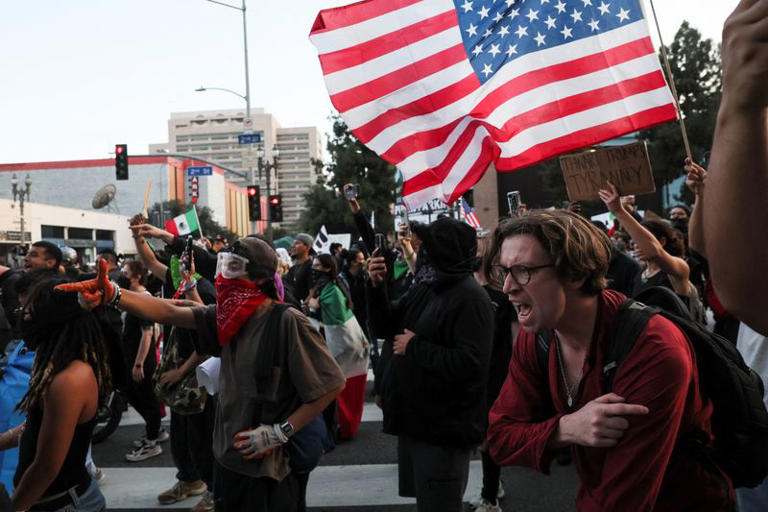 Demonstrators react to crowd control munitions being shot at them as protests against federal immigration sweeps continue, in downtown Los Angeles, California, U.S. June 10, 2025. REUTERS/Leah Millis