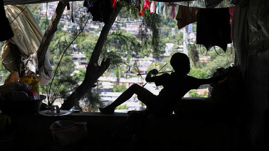 A child builds a kite at a shelter for families displaced by gang violence in Port-au-Prince, Haiti, Thursday, June 5, 2025.