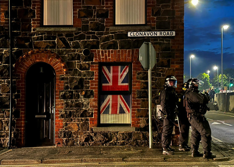 A house displays a British flag in its window as police respond to the disorder in Ballymena (Liam McBurney/PA Wire)