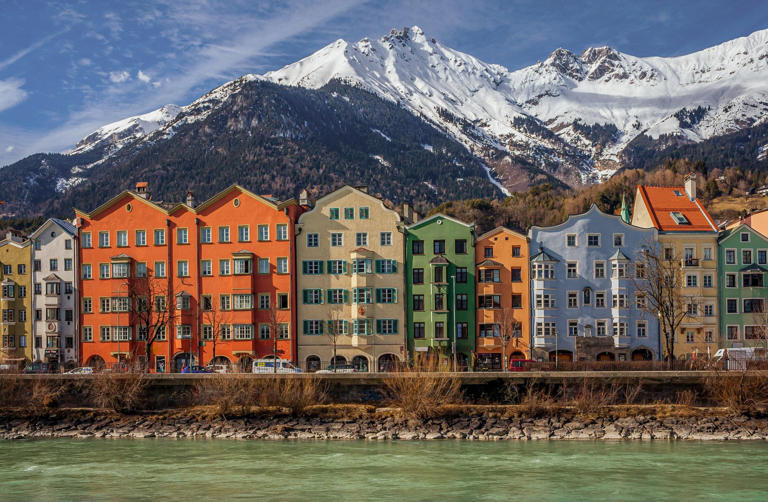The colourful facades of historical buildings, backdropped by snow-capped mountains, line the riverfront in the Old Town of Innsbruck. Photo: Shutterstock