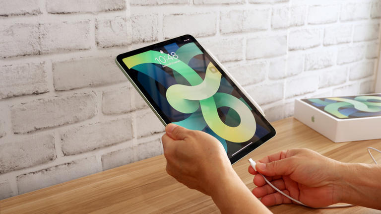 Person preparing to charge an iPad Air