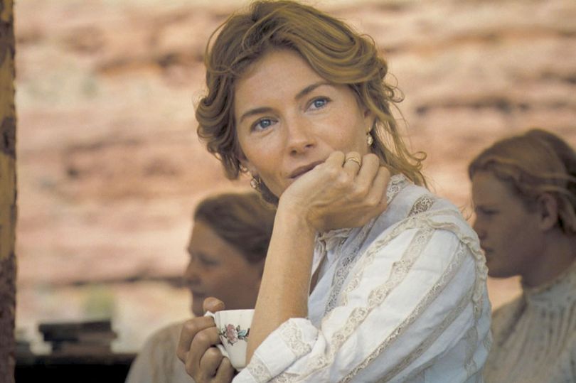 A woman in white leans her face on her hand