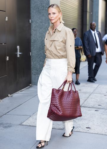 Charlize Theron setzt bei ihrem Look auf Understatement und beweist, dass die Kombi aus weißer Hose und schwarzen Sandaletten mühelos stilsicher ist