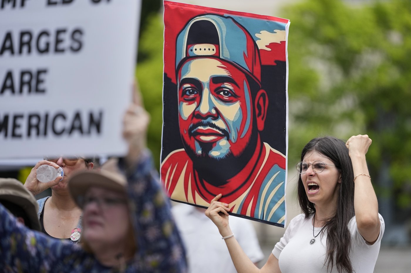 Brianna O'Keefe yells as she holds a portrait of Kilmar Obrego Garcia during a protest outside the federal courthouse Wednesday, June 25, 2025, in Nashville, Tenn. (AP Photo/George Walker IV)
