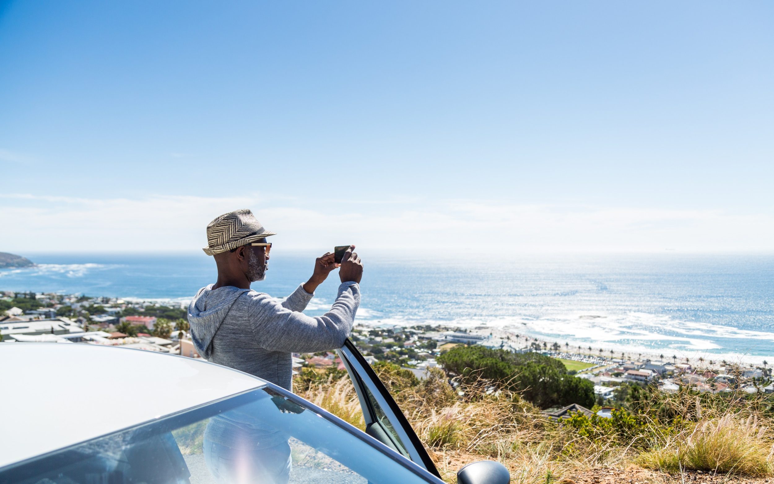 Tourist photographing sea view with smart phone