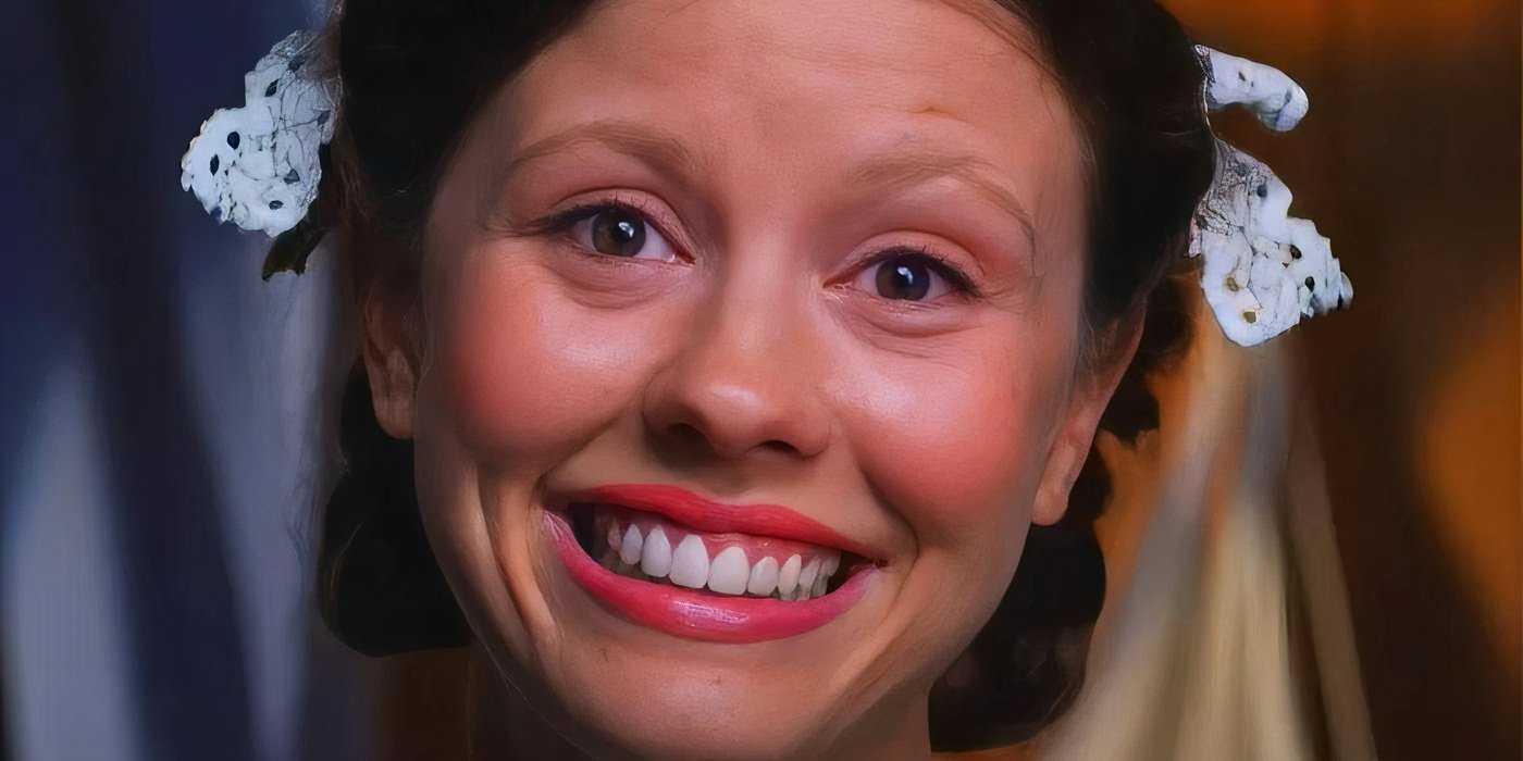 Mia Goth in Pearl smiling big at something.