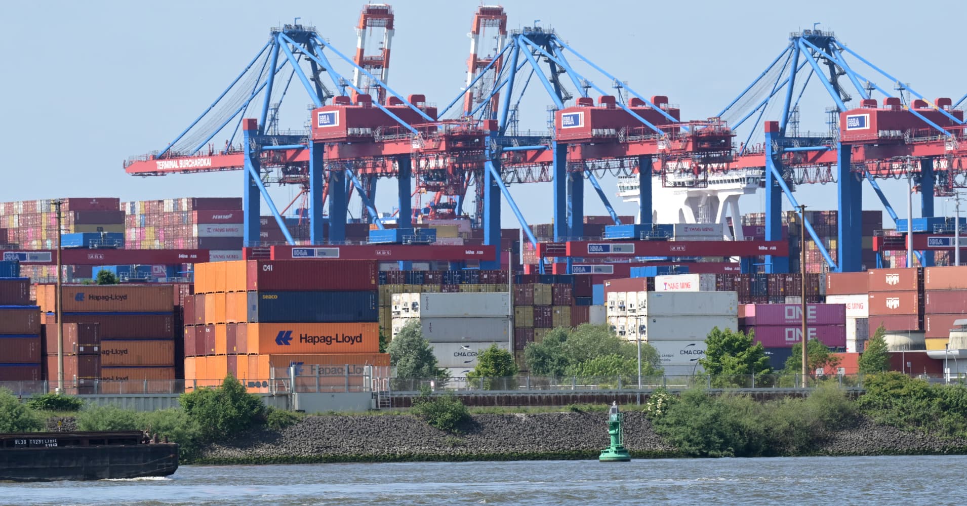 Cargo shipping containers wait to be loaded by cranes on container ships at the Burchardkai container terminal at the harbour of Hamburg, northern Germany, on June 3, 2025.