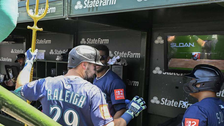 Seattle Mariners catcher Cal Raleigh (29) celebrates in the dugout with outfielder Julio RodrÌguez (44) and first baseman Donovan Solano (39) after he hits a home run against the Chicago Cubs during the first inning at Wrigley Field on June 20. | Matt Marton-Imagn Images
