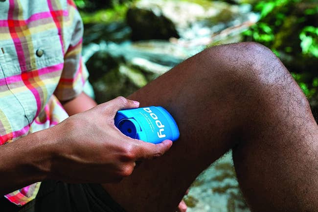 model holding the anti-chafe stick to their inner thigh