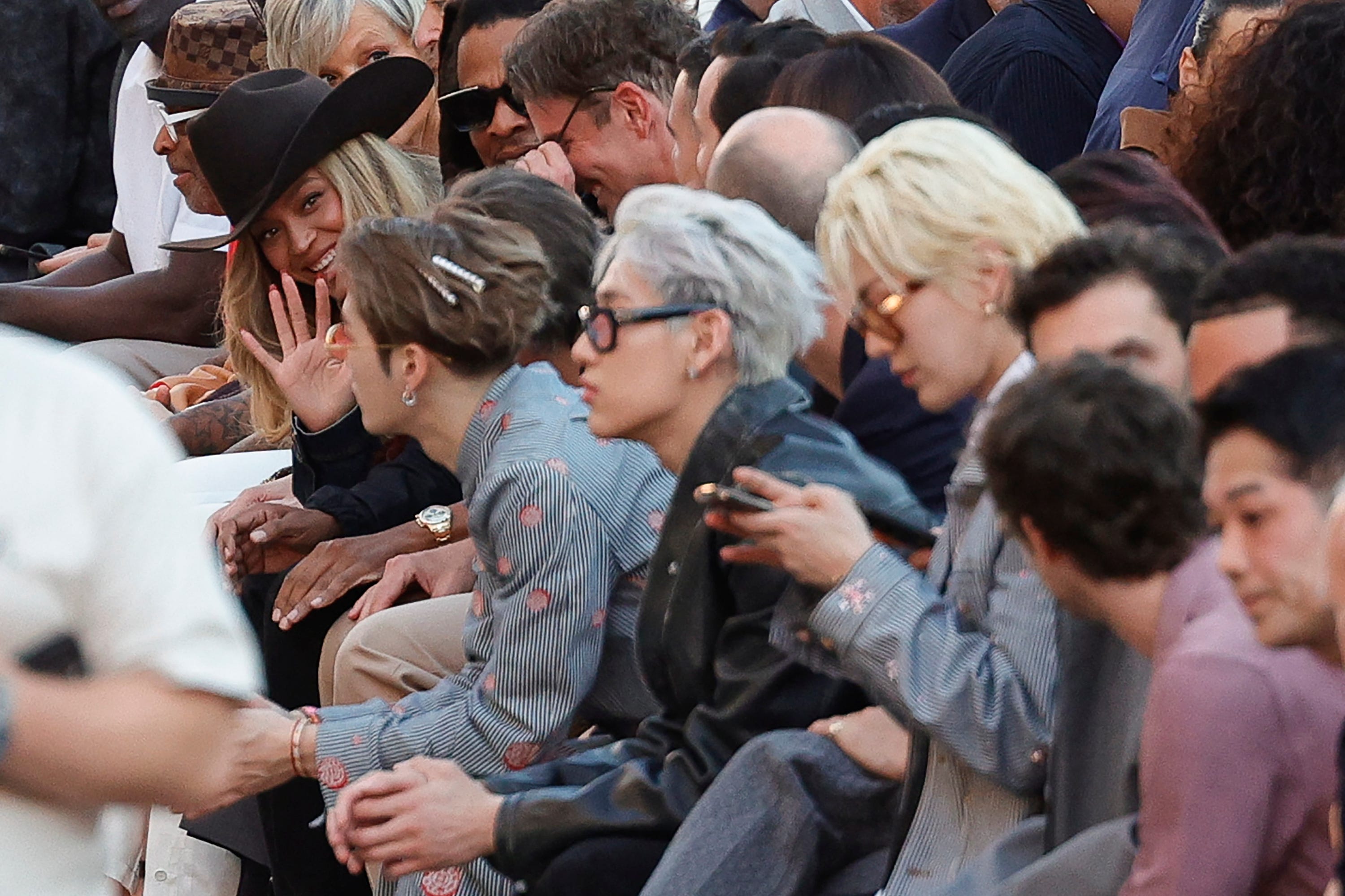 Beyoncé waves at someone at the LV runway show during Paris Fashion Week.