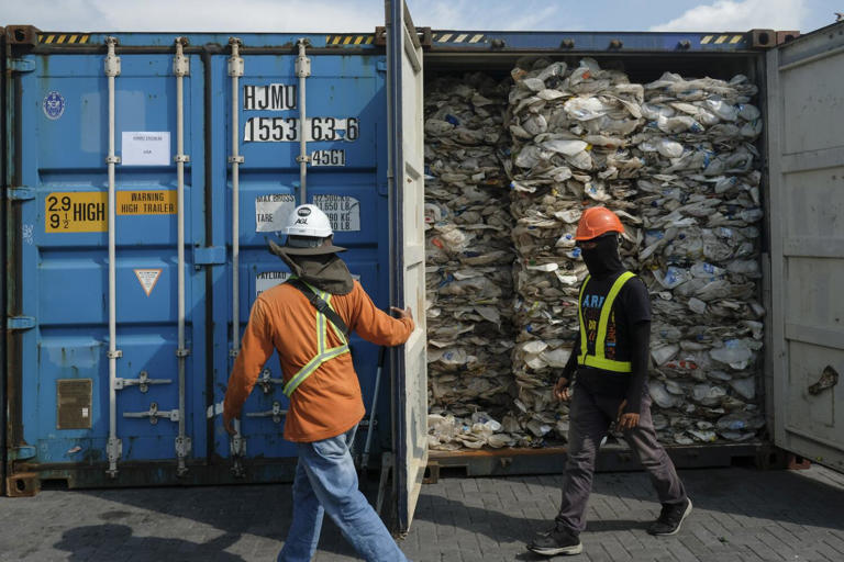 Workers open the door of plastics waste shipment from Australia before sending back to the country of origin in Port Klang on May 28, 2019. A total of 3,000 metric tonnes of contaminated plastic waste will be shipping back to their countries of origin today, signalling Malaysias effort to take the lead in the global crusade against unscrupulous export of scrap. (Photo by ((Adli Ghazali/Anadolu Agency via Getty Images))