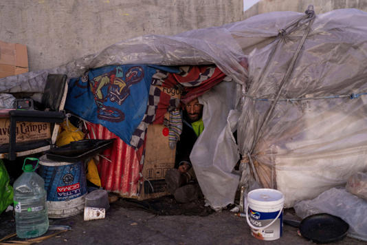 Luis Santacruz looks out from his makeshift home during cold weather in downtown Montevideo (AP)