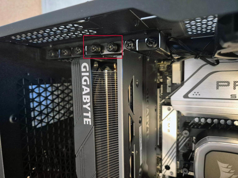 An image showing a graphics card, highlighting the screws that keep it in place.
