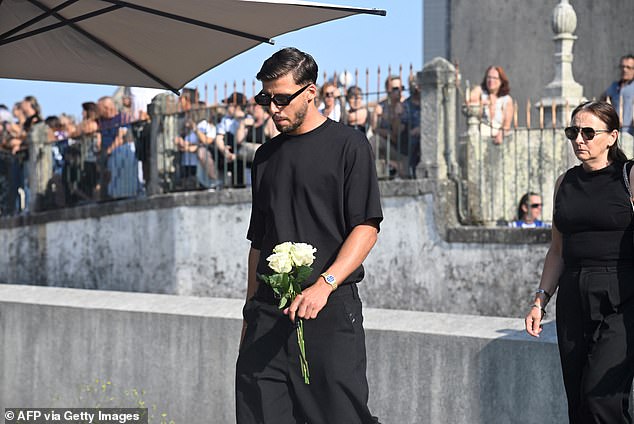 Dias wore all black as he carried a bouquet of flowers inside the church ahead of the ceremony