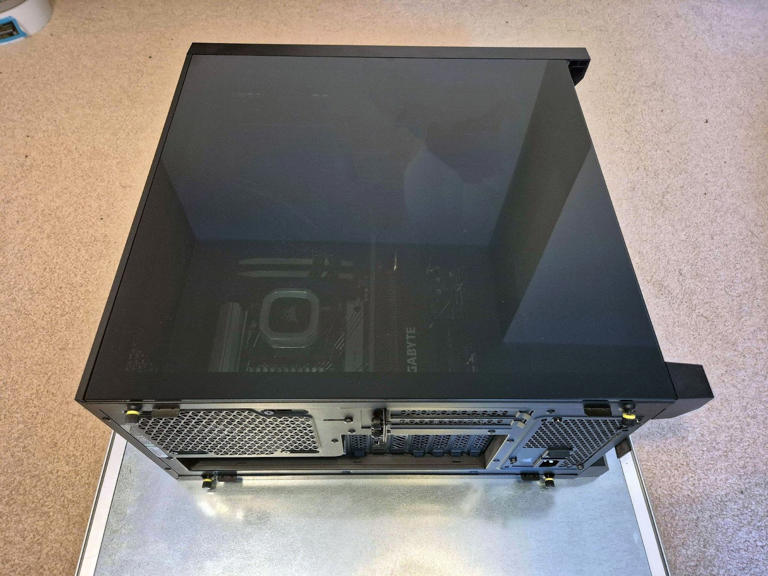 A PC rests on its side, showing the rear and side panels of the chassis.