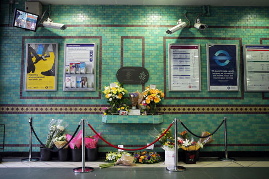 Flowers left by the July 7 memorial plaque at Aldgate Station (PA Archive)