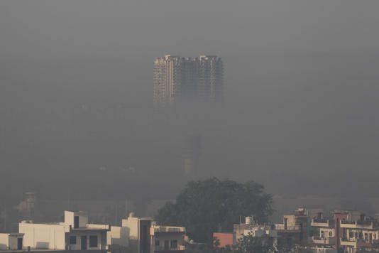 A residential building engulfed in smog is pictured during the morning in Faridabad district of India's Haryana (AFP via Getty Images)