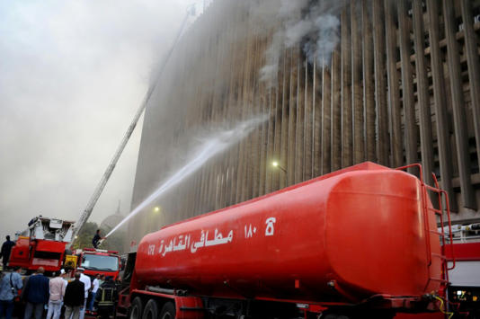 رجال الإطفاء يخمدون النيران بعد اندلاع حريق في محطة سنترال رمسيس للاتصالات في وسط القاهرة في 7 تموز/يوليو 2025