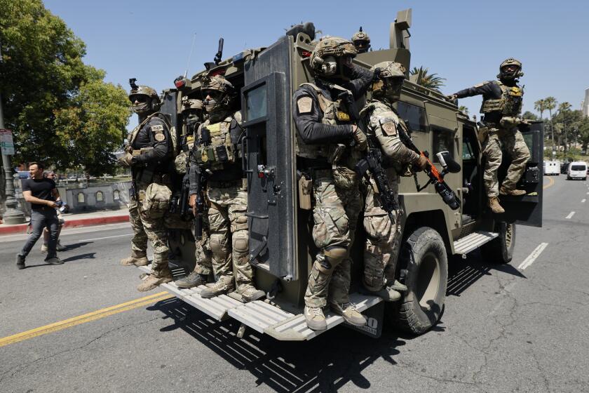 LOS ANGELES, CALIF. JULY 7, 2025 - Federal immigration agents near MacArthur Park in the Westlake area on July 7, 2025. (Carlin Steihl / Los Angeles Times)