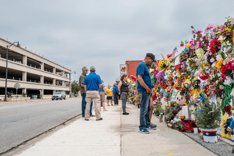 Brandon Bell/Getty Images - PHOTO: Community members gather at a memorial to honor the lives lost in the flash floods that claimed more than 120 lives on July 13, 2025 in Kerrville, Texas.