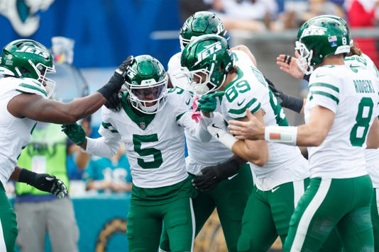 Dec 15, 2024; Jacksonville, Florida, USA; New York Jets wide receiver Garrett Wilson (5), quarterback Aaron Rodgers (8), and tight end Jeremy Ruckert (89) celebrate a touchdown against the Jacksonville Jaguars during the first quarter at EverBank Stadium. Mandatory Credit: Morgan Tencza-Imagn Images