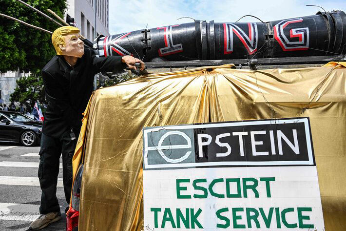 Imagem do dia 14 de junho mostra um manifestante com uma máscara de Trump ao lado de uma placa escrita "Serviço de escolta de tanques Epstein", durante um protesto contra o presidente dos EUA. Trump alimentou por anos teorias de conspiração contra Epstein Foto: Ronaldo Schemidt/AFP