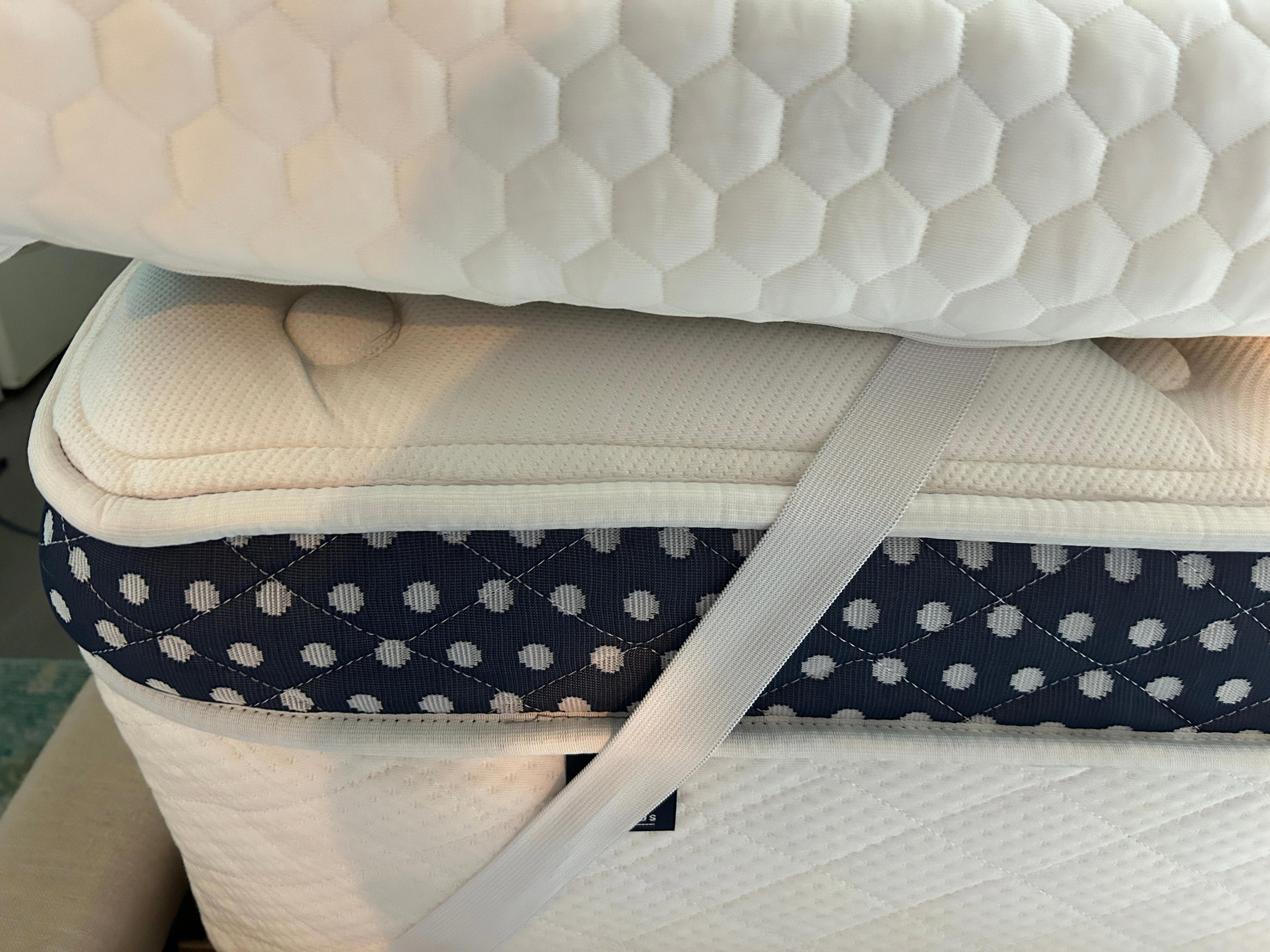 mattress topper on a mattress, held together by straps