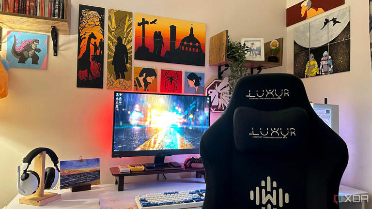 A gaming PC and gaming chair with video game art paintings on the wall.