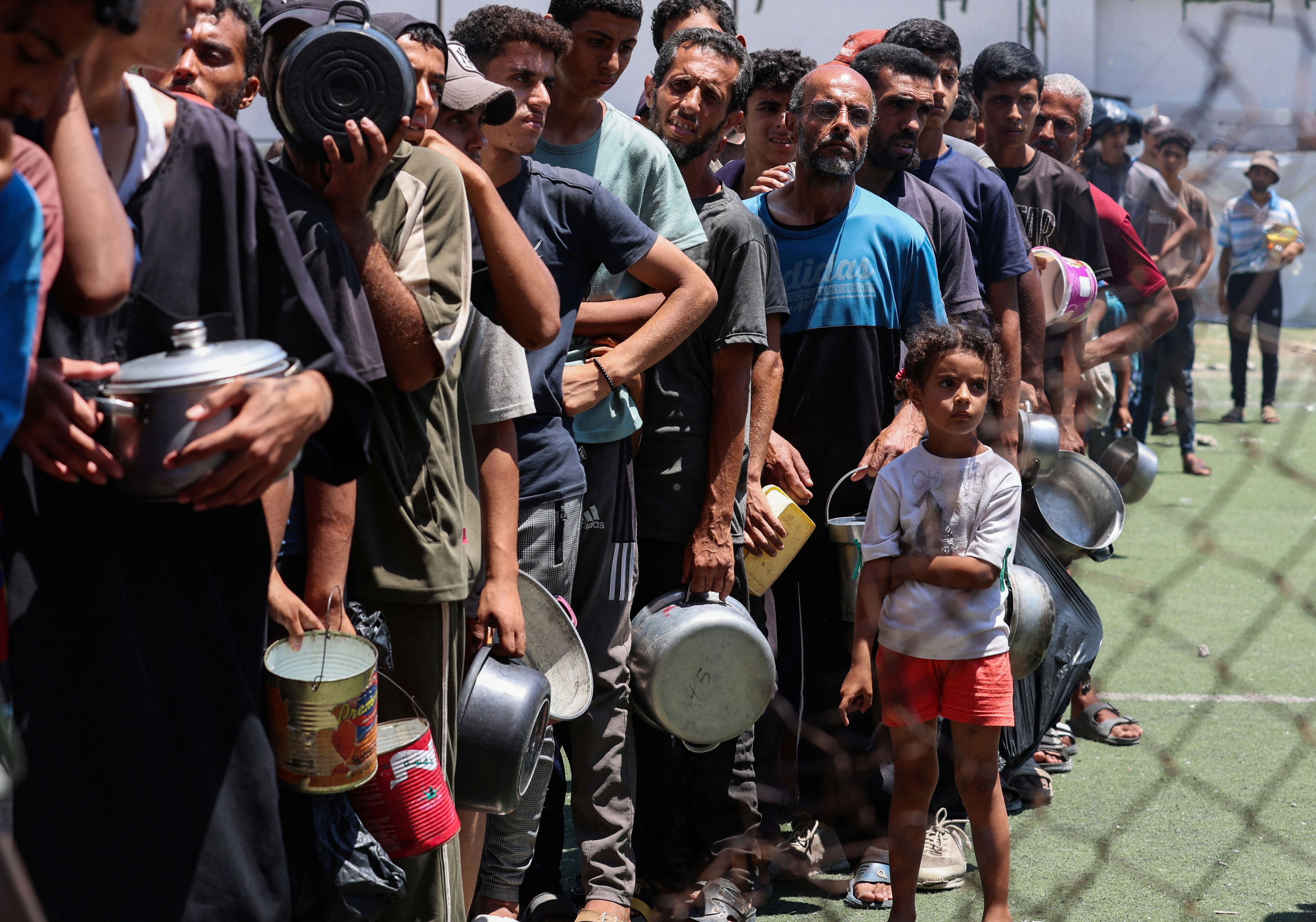 Palestinians gather to receive food from a charity kitchen (REUTERS)