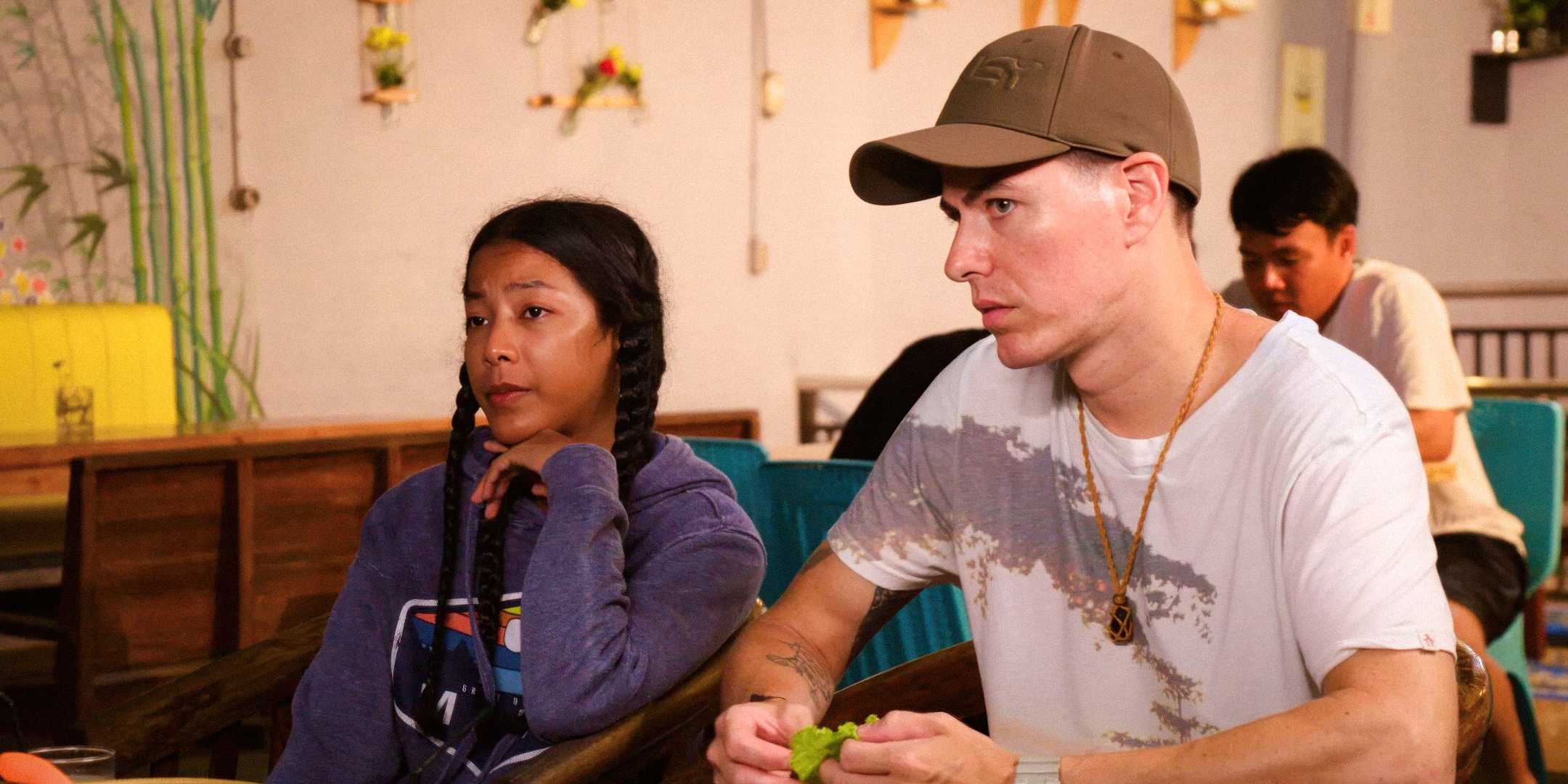 90 Day Fiance James Solis & Meitalia Tatha sitting at a table looking across nervously