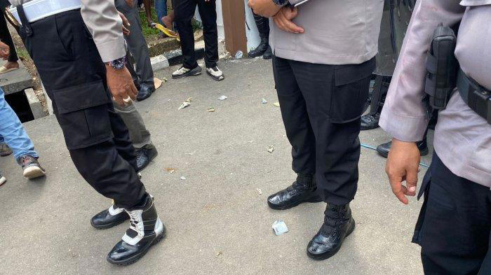 PELEMPARAN UANG - Aksi pelemparan uang pecahan seribu dan dua ribu yang dilakukan massa aksi daat melakukan aksi demo sopir mobil pikap di depan Polda NTT, Selasa (8/7/2025).