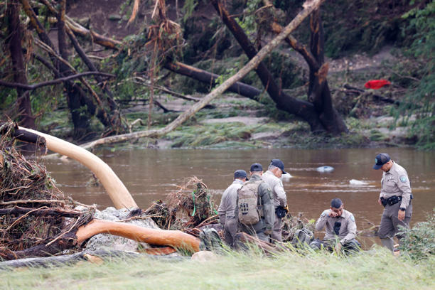 Law enforcement officers gather along the Guadalupe River, Saturday, July 5, 2025, in Hunt. A flash flood swept through the area early Friday morning.