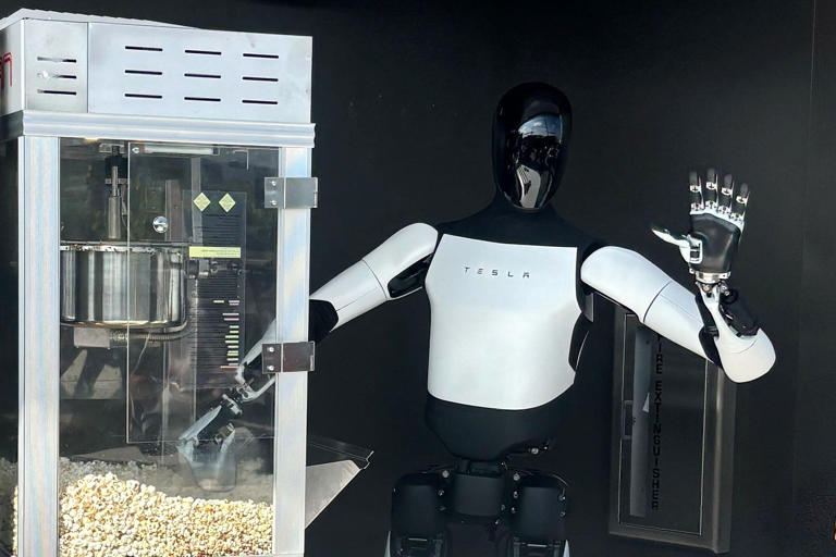 An Optimus robot waves as it serves popcorn at the Tesla Diner on Monday. (Angela Yang / NBC News)