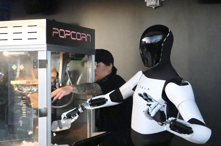 A Tesla Optimus robot hands out popcorn to customers on the rooftop of the Tesla Diner. ((Lauren Ng / Los Angeles Times))