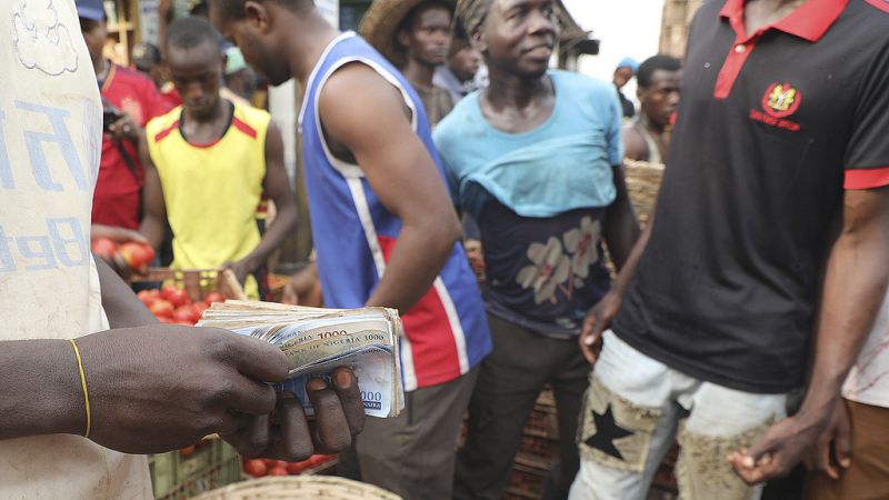 Un vendeur compte la monnaie locale au marché Mile 12 à Lagos, au Nigeria, le 16 février 2024