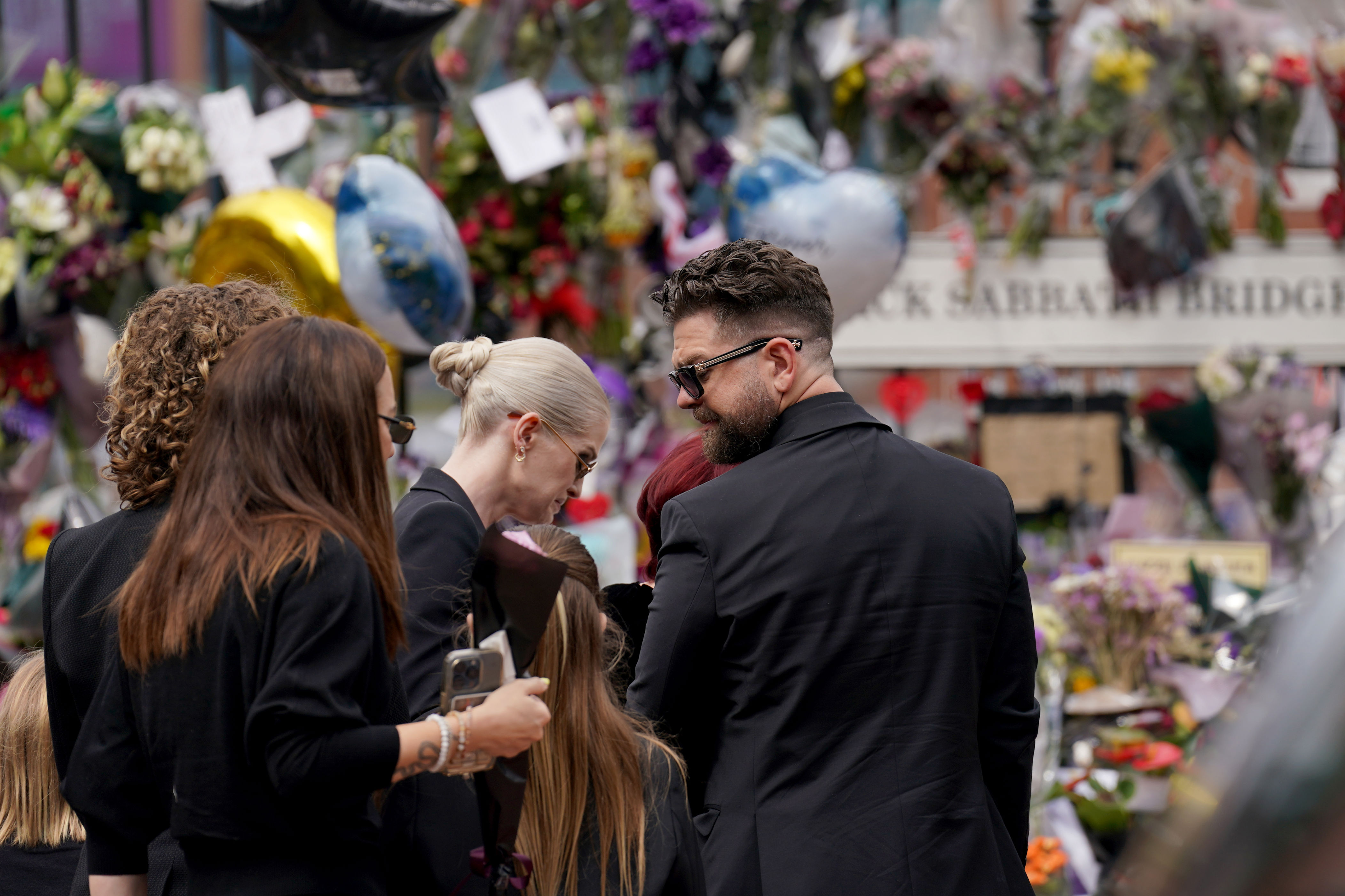 The family of Ozzy Osbourne appeared emotional as they viewed the messages and floral tributes left in his honour (Joe Giddens/PA) (PA Wire)