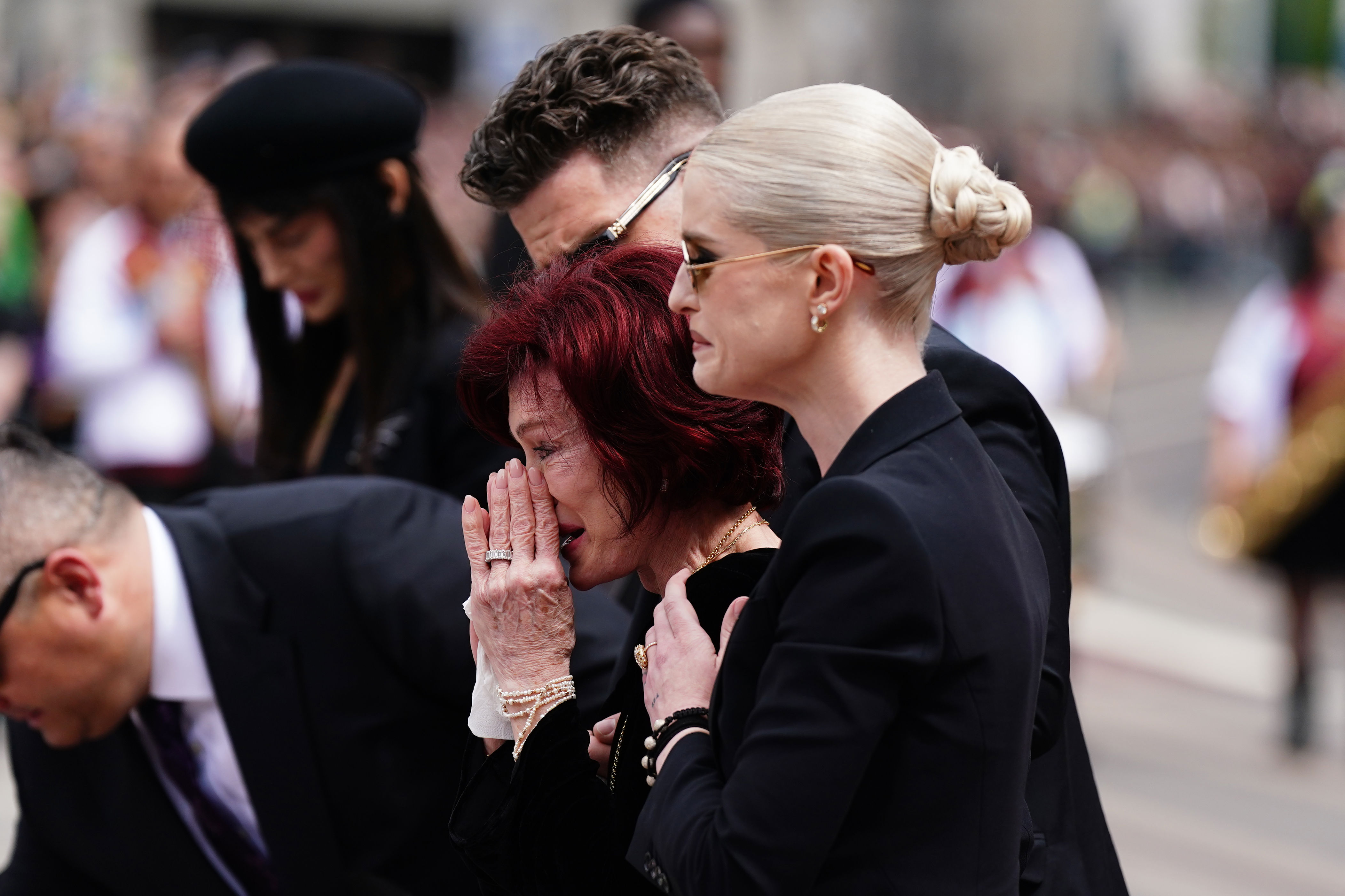 Sharon and Kelly view the messages and floral tributes left at the Black Sabbath Bridge bench on Broad Street (Jacob King/PA Wire)