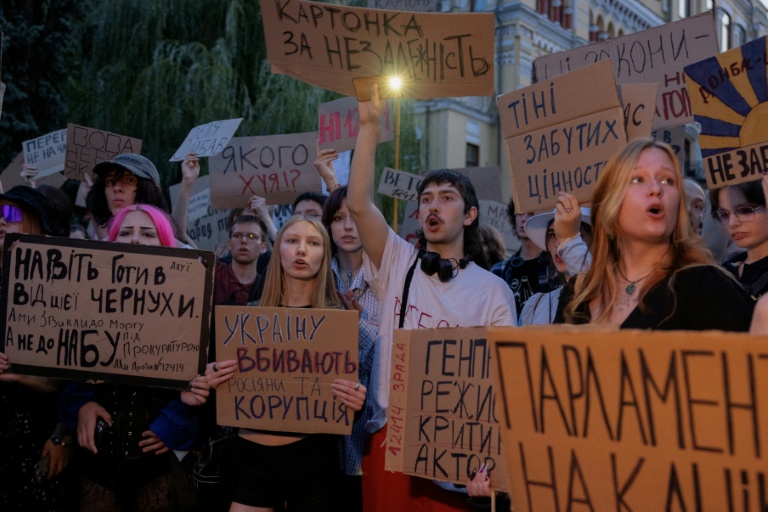 Des manifestants crient des slogans et brandissent des pancartes lors d'une manifestation contre une loi qui supprime l'indépendance des agences de lutte contre la corruption NABU et SAPO, à Kiev, le 24 juillet 2025