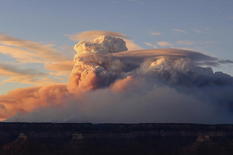 In this photo provided by Lin Chao, 'fire clouds' form near the Bright Angel Trailhead at the South Rim in the Grand Canyon, Ariz., Sunday, July 27, 2025. (Lin Chao via AP)